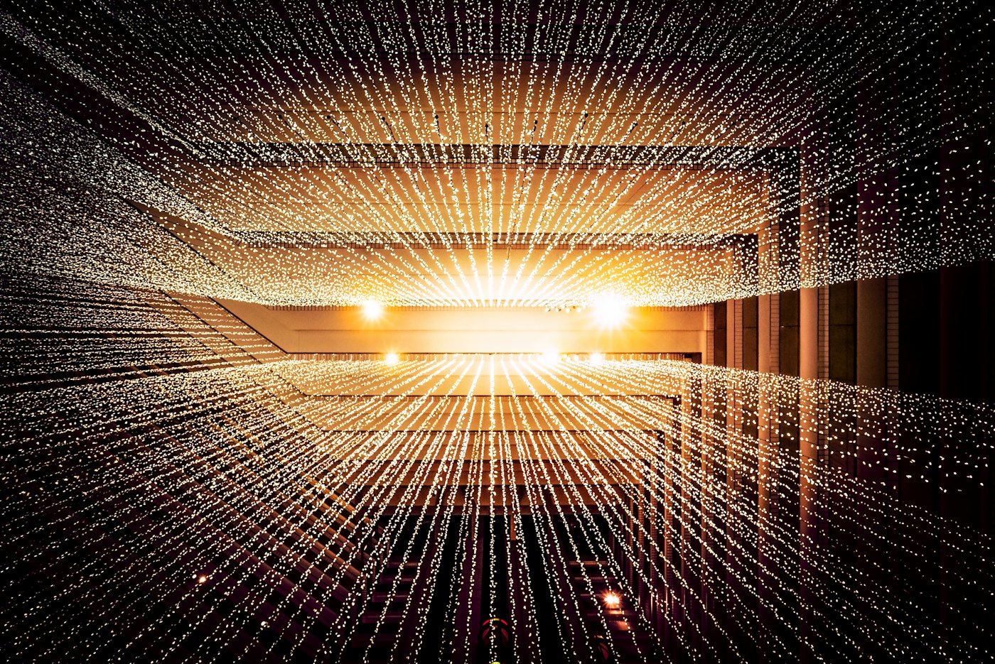 Worm's eye view of a data center ceiling with symmetrical server infrastructure receding upward