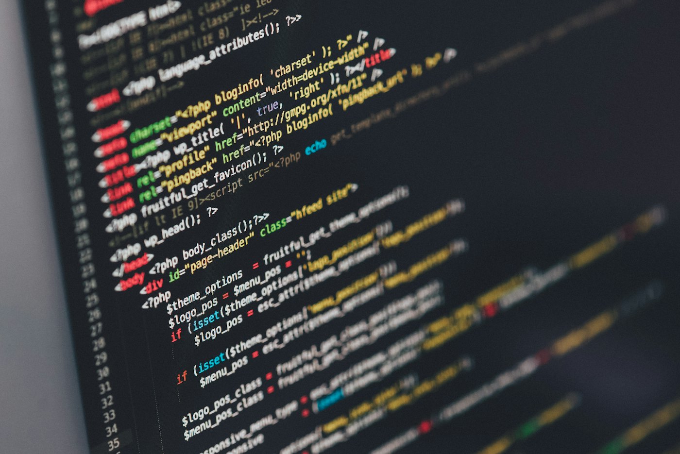 Developer working at a dark monitor displaying code — the real-world context HyperQuery/PG operates in